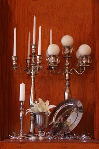 Silver single candle stick + stubby. 76 cm Silver table candelabra no.2. Silver goblet. Mother of pearl / silver serviette rings. (Stainless steel) underplate (chargerplate). Candle snuffer. 76 cm Silver table candelabra no.1 + clear candle collar. 2 m Clear crystal battery light